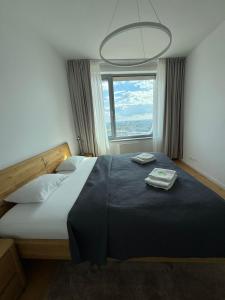a bedroom with a large bed with two towels on it at Skau Sky Park Mint by Zaha Hadid 22 Floor 1 Tower Free Parking in Staré Mesto