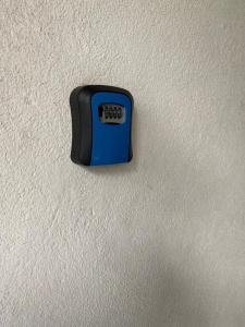 a black and blue alarm clock on a white wall at BAYU BEACH APARTMENT By FIONAMALIK GUESTHOUSES in Port Dickson