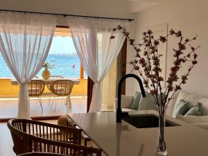 een woonkamer met een tafel en uitzicht op de oceaan bij LUXURY PROPERTY ALTEA, BeachFront in Altea la Vieja