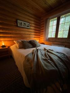 a bedroom with a bed in a log cabin at Charming Log Chalet, Ylläs, Wifi, 400m to restaurants in Kolari