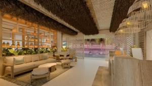 a lobby with a couch and chairs and a table at Hotel Indigo Playa del Carmen by IHG in Playa del Carmen