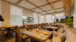 a restaurant with wooden tables and chairs and candles at Hotel Indigo Playa del Carmen by IHG in Playa del Carmen