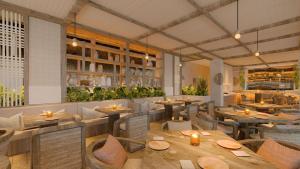 a restaurant with wooden tables and chairs and plants at Hotel Indigo Playa del Carmen by IHG in Playa del Carmen
