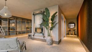 a living room with a vase with a plant in it at Hotel Indigo Playa del Carmen by IHG in Playa del Carmen +17 photos