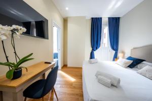 a hotel room with two beds and a desk with a vase at MAMA Luxury in Rome