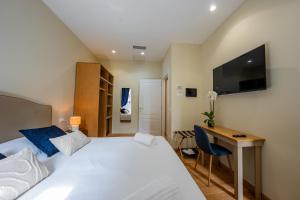 a bedroom with a bed and a desk and a television at MAMA Luxury in Rome