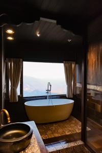 a large bath tub in a bathroom with a window at MiAmi Mountain Retreat in Bắc Yên