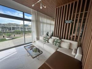 a living room with a couch and a large window at Studio Amalfi piscina academia coz completa in Juiz de Fora