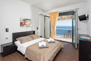 a bedroom with a bed with a view of the ocean at Anna Nissaki in Corfu +46 photos