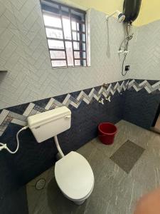 a bathroom with a toilet and a shower at Omisha Beach Stay Gokarna in Gokarna