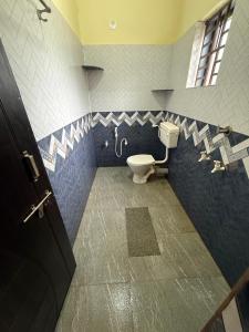a bathroom with a toilet in a blue and white bathroom at Omisha Beach Stay Gokarna in Gokarna