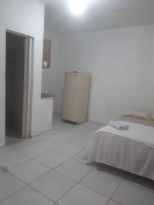 a white room with a bed and a refrigerator at Centro - Praia de Iracema - Pousada Panorama do Mar in Fortaleza