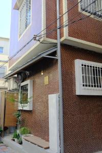 a red brick building with a window and a door at Tomo 伴 in Tainan
