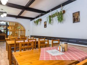 a dining room with wooden tables and wooden chairs at Penzion Ráj in Blíževedly