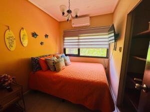 1 dormitorio con cama de color naranja y ventana en Essenz Bahía, en El Níspero 33 fotos más