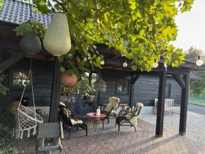 a patio with chairs and a table and a building at Natuurhuisje het Steenuiltje op een prachtige plek in Wekerom