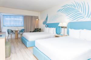 a hotel room with two beds and a table at Sherry Frontenac Oceanfront in Miami Beach +71 photos