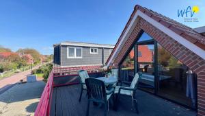 a patio with a table and chairs on a deck at Haus Gartenstraße Ferienwohnung Nemo in Borkum
