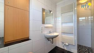 a bathroom with a sink and a mirror at Haus Gartenstraße Ferienwohnung Nemo in Borkum +30 photos