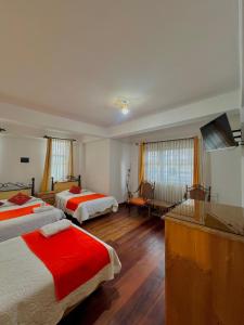 a hotel room with two beds with red sheets at Hotel Avenida in La Paz +50 photos