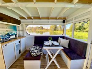 a kitchen and dining area of a caravan with a table at HAUSBOOT - Schwimmende feststehende Ferienwohnung direkt auf der Havel mit Weitblick aufs Wasser in Ketzin