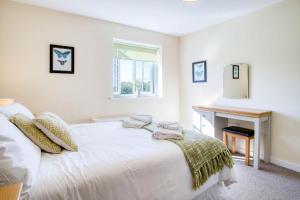a white bedroom with a bed with towels on it at The Barn - 4 Bedroom - Tyn-Y-Coed Farm - Cardiff in Creigiau