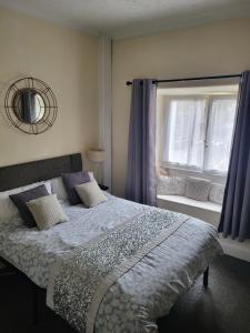 - une chambre avec un lit doté de rideaux bleus et d'une fenêtre dans l'établissement Station Guesthouse - key pad entry with parking, à Lancaster