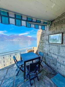 Una mesa y sillas en un balcón con vista al agua. en Casa Azzurra, en Germignaga