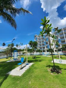a park with a palm tree and a building at The Ultimate Escape in Negombo +15 photos