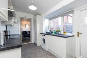 a kitchen with a washer and dryer in a apartment at Newly Renovated 3br House Near Hospital & Uni in Sunderland