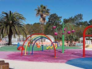 einen Spielplatz in einem Park mit farbenfroher Spielausrüstung in der Unterkunft Douce Escale in Lège-Cap-Ferret