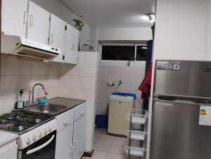 a small kitchen with a sink and a refrigerator at Confortable Apartamento in Maracaibo