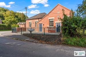 a brick house with a fence in front of it at The Old Chapel in Dilhorne