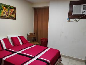 a bedroom with a pink and white bed and a fan at Confortable Apartamento in Maracaibo