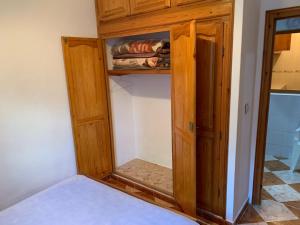 a wooden cabinet with a mirror in a room at Zellaka apartamento2 in Asilah