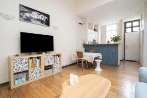 a living room with a television and a table at Maison Loft Verzy - Nomad by Welkeys in Paris
