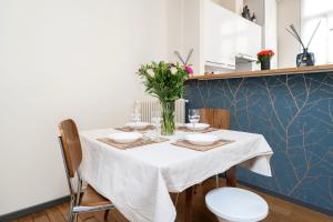 a dining room table with a vase of flowers on it at Maison Loft Verzy - Nomad by Welkeys in Paris