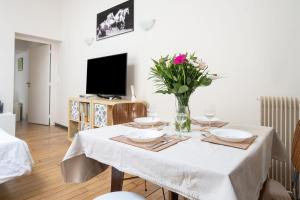 a dining room table with a vase of flowers on it at Maison Loft Verzy - Nomad by Welkeys in Paris