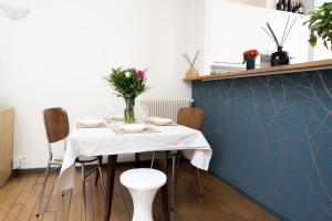 a dining room with a table with flowers on it at Maison Loft Verzy - Nomad by Welkeys in Paris