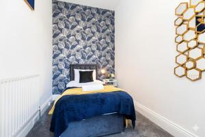 a small bedroom with a bed with a blue blanket at Newly Renovated 3br House Near Hospital & Uni in Sunderland
