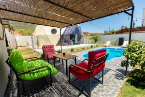 a patio with chairs and a table and a pool at Anamur Deluxe Glamping Dome in Anamur