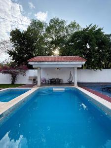 a swimming pool with a gazebo in a yard at Alojamiento para 2 con alberca in Mérida