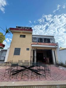 a group of chairs sitting in front of a building at Alojamiento para 2 con alberca in Mérida