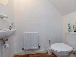 a white bathroom with a toilet and a sink at Pass the Keys Modern Office Driveway Near Crok Durham in Willington +22 photos