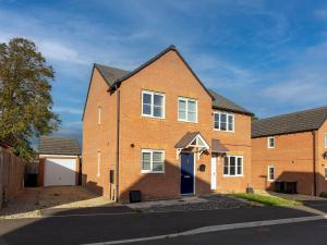 a brick house with a blue door on a street at Pass the Keys Modern Office Driveway Near Crok Durham in Willington