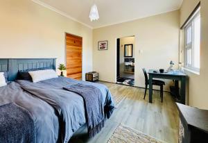 a bedroom with a bed and a desk at Boardrooms Kite Accommodation in Cape Town