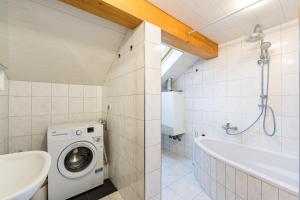 a bathroom with a washing machine and a bath tub at Ferienwohnung Monteurzimmer Fährmann in Murg +10 photos