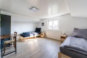 a bedroom with two beds and a desk and a window at Ferienwohnung Monteurzimmer Fährmann in Murg