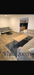 a living room with two tables and a couch at White Quenn Apartments in Sanski most +2 photos