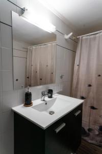 a bathroom with a sink and a shower at Tasos Apartment in Leonidio +15 photos